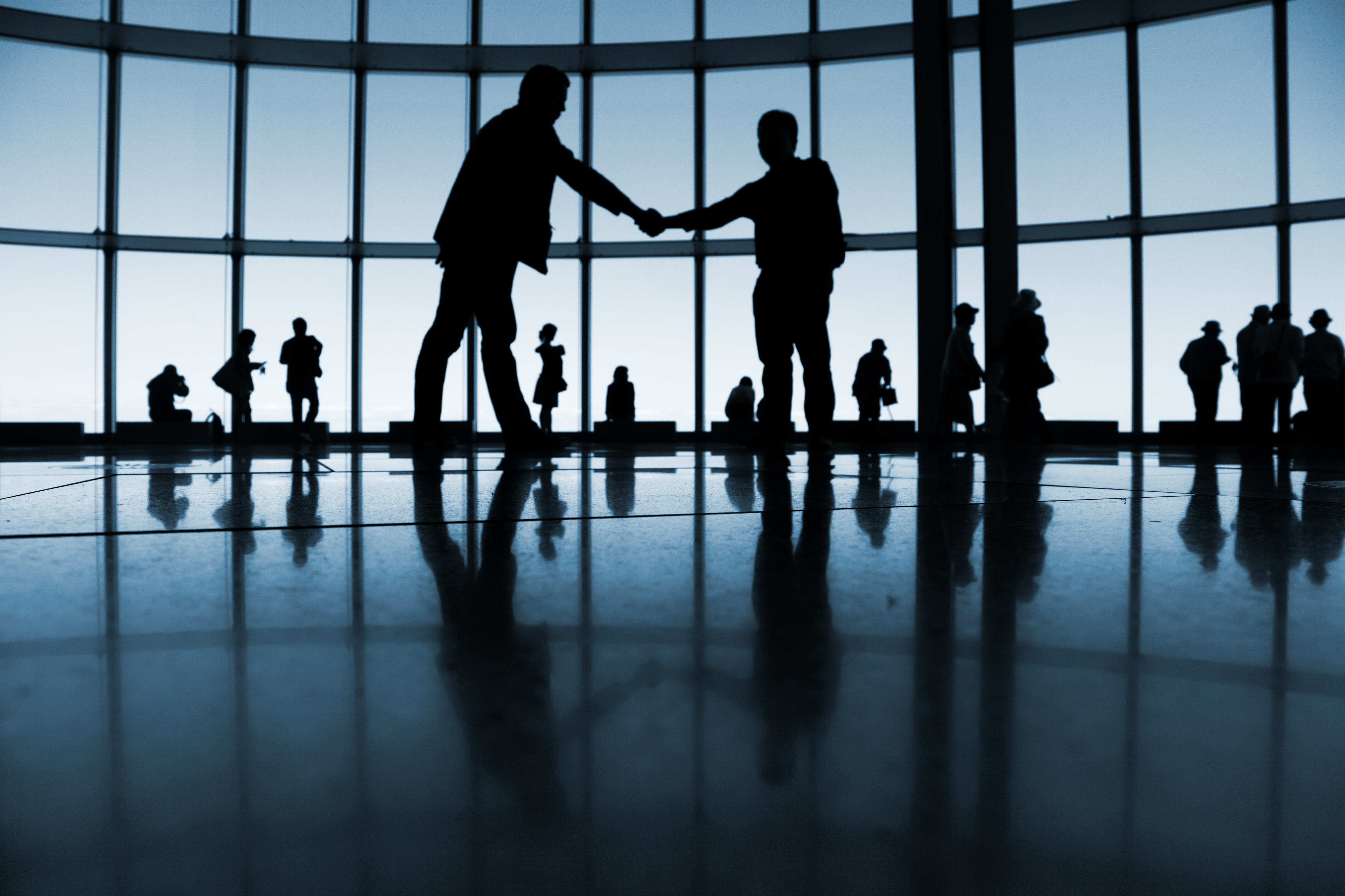 Silhouetted people in a large public space.