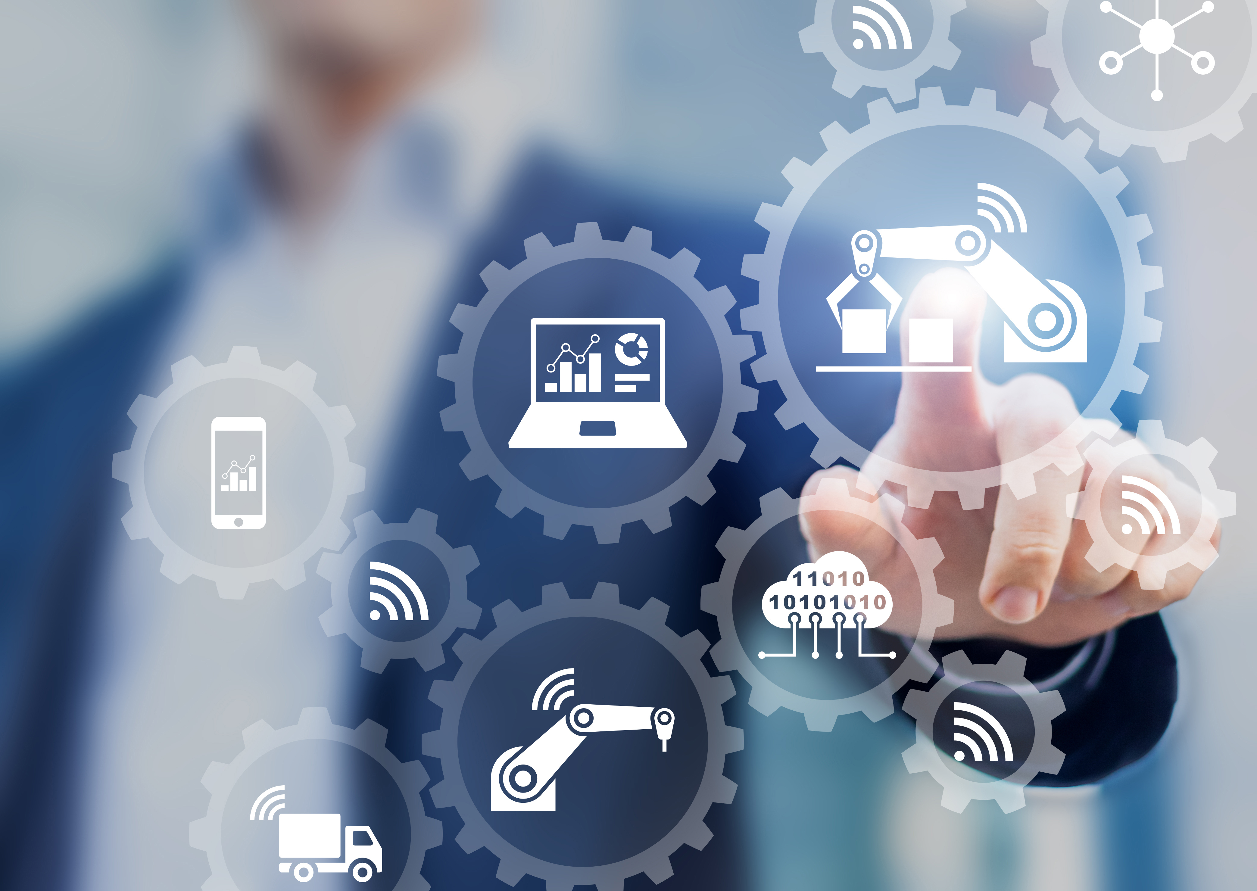 Smart factory and industry 4.0 concept with connected production robots exchanging data with internet of things (IoT) and cloud computing technology, businessman touching interface with icons in gears