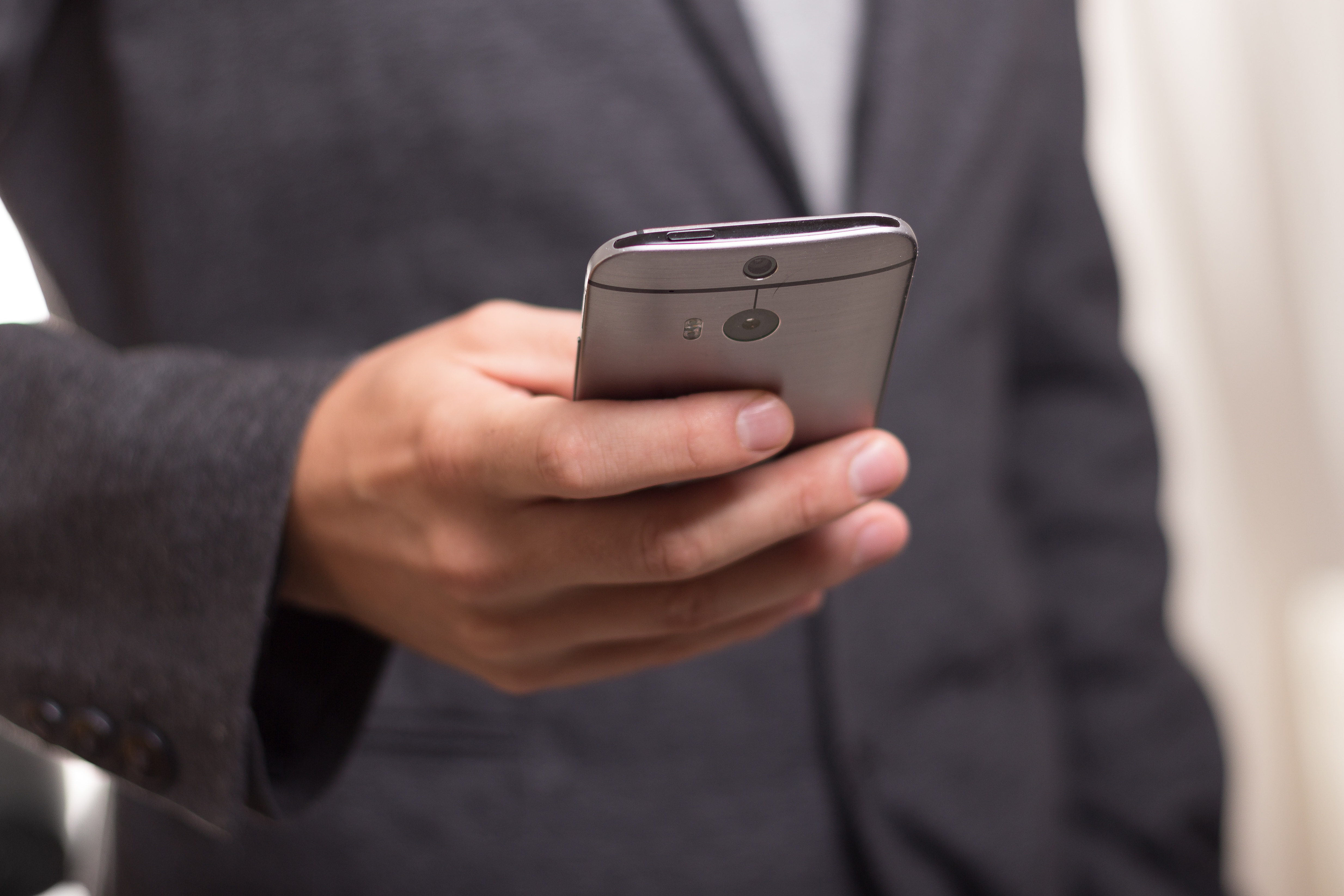 Canva - Man Wearing Black Suit Jacket Holding Gray Htc Android Smartphone