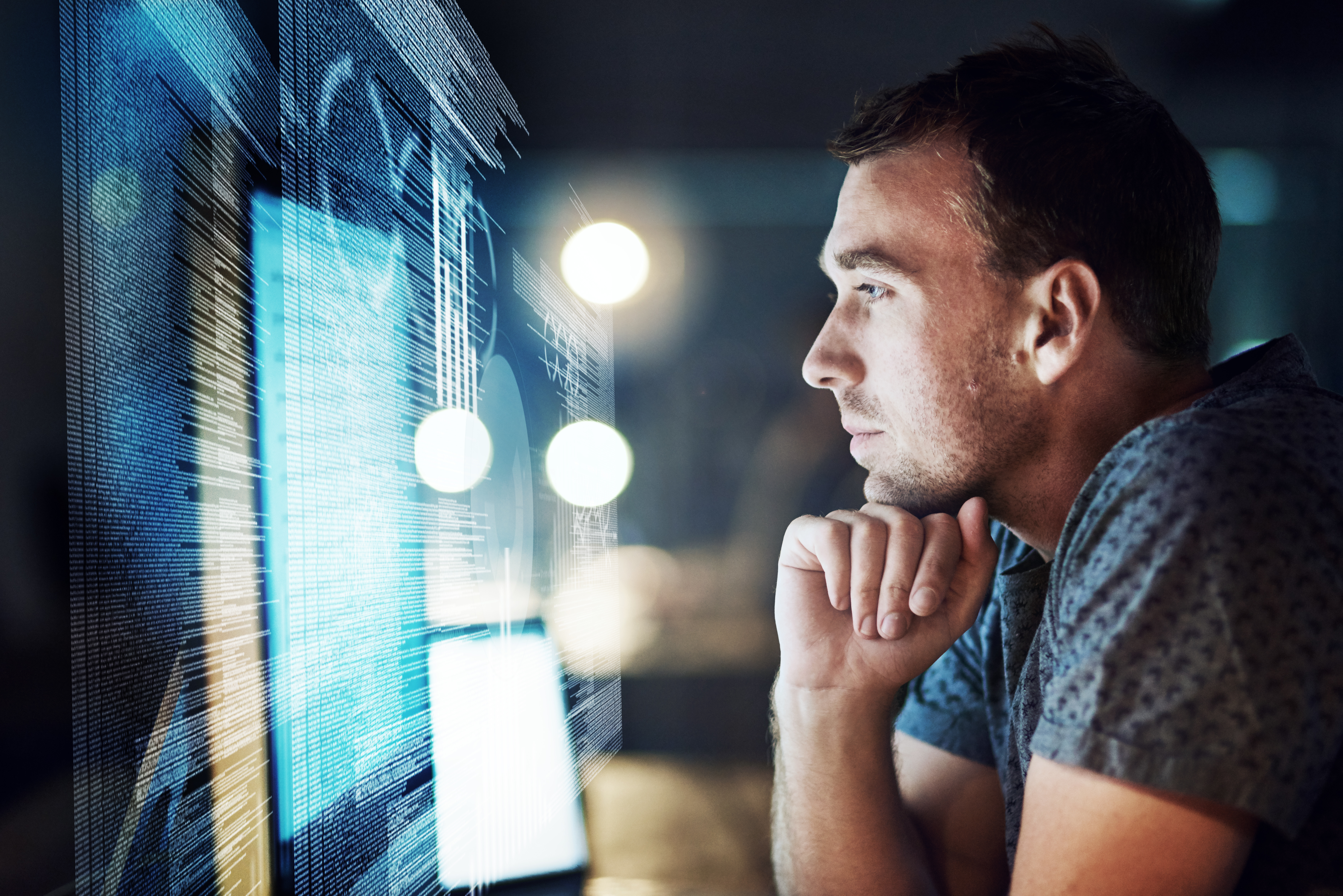 Shot of a programmer working on a computer code at night