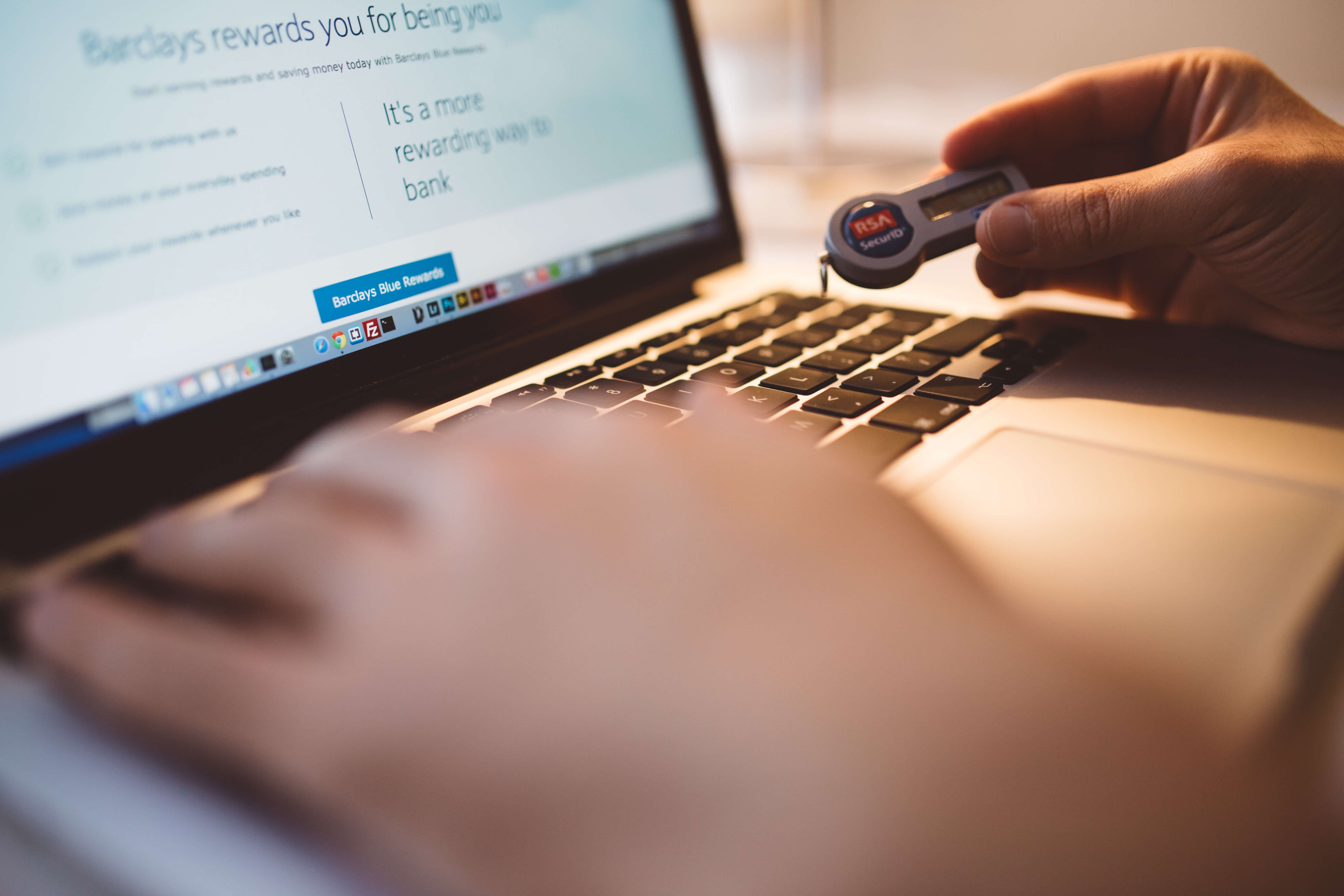 Canva - Person Holding Electronic Device While Using Its Macbook Laptop