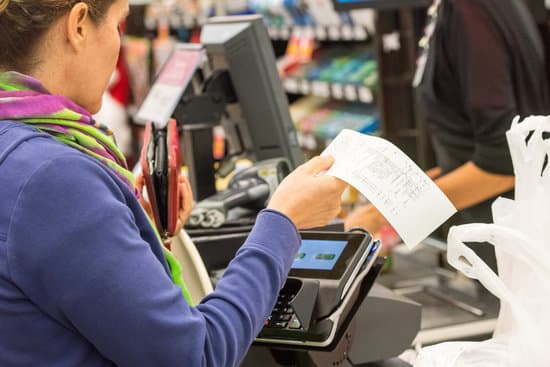 Caucasian woman electronic signing her bill at the supermarket