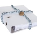 Folder with confidential information secured by metal chain and lock. Isolated on white