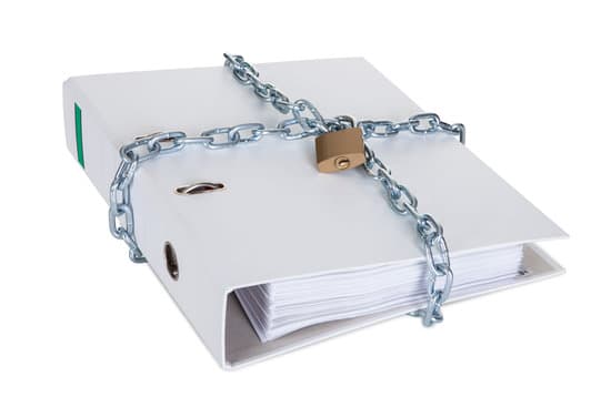 Folder with confidential information secured by metal chain and lock. Isolated on white
